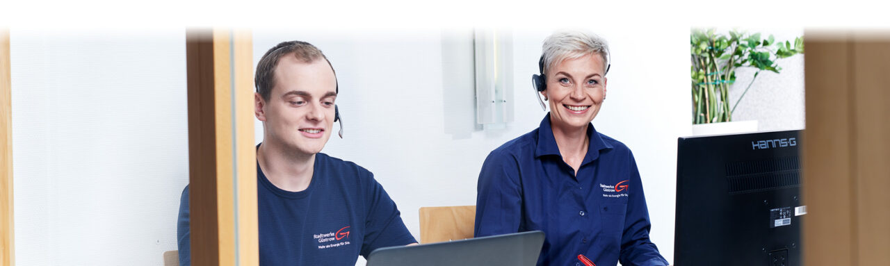 Zwei Mitarbeiter des Kundenservice der Stadtwerke Güstrow mit Headset am Arbeitsplatz