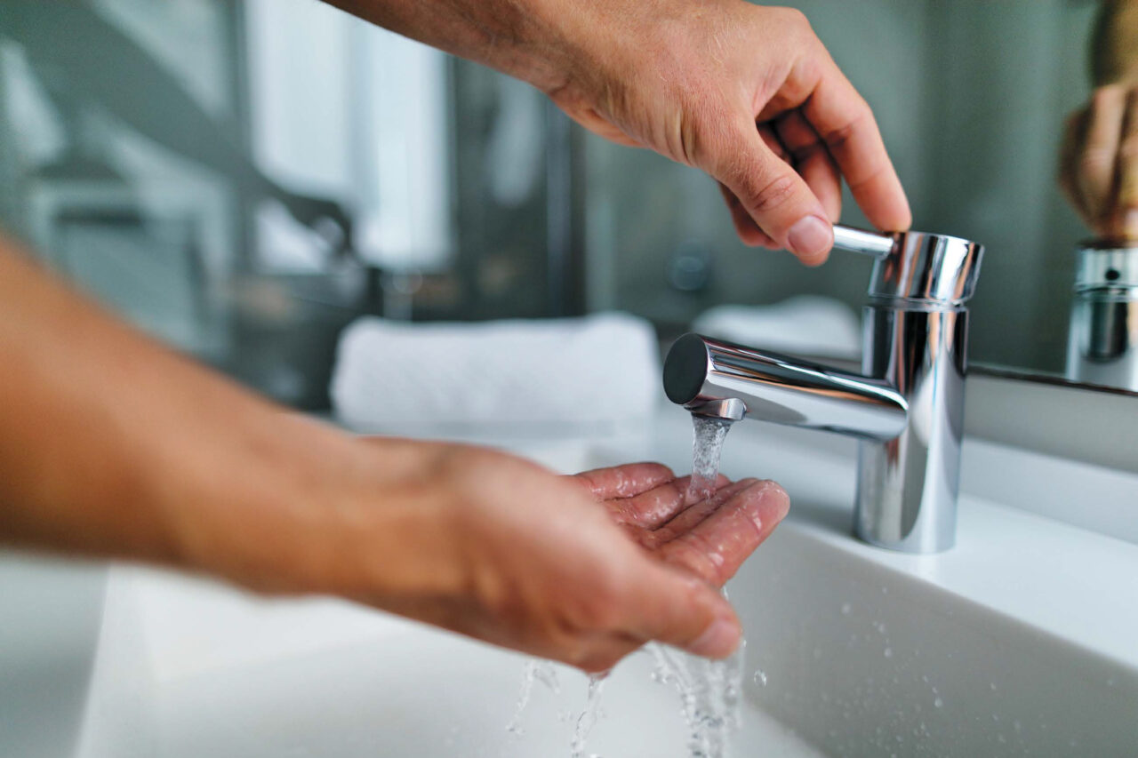 Hände unter einem laufenden Wasserhahn